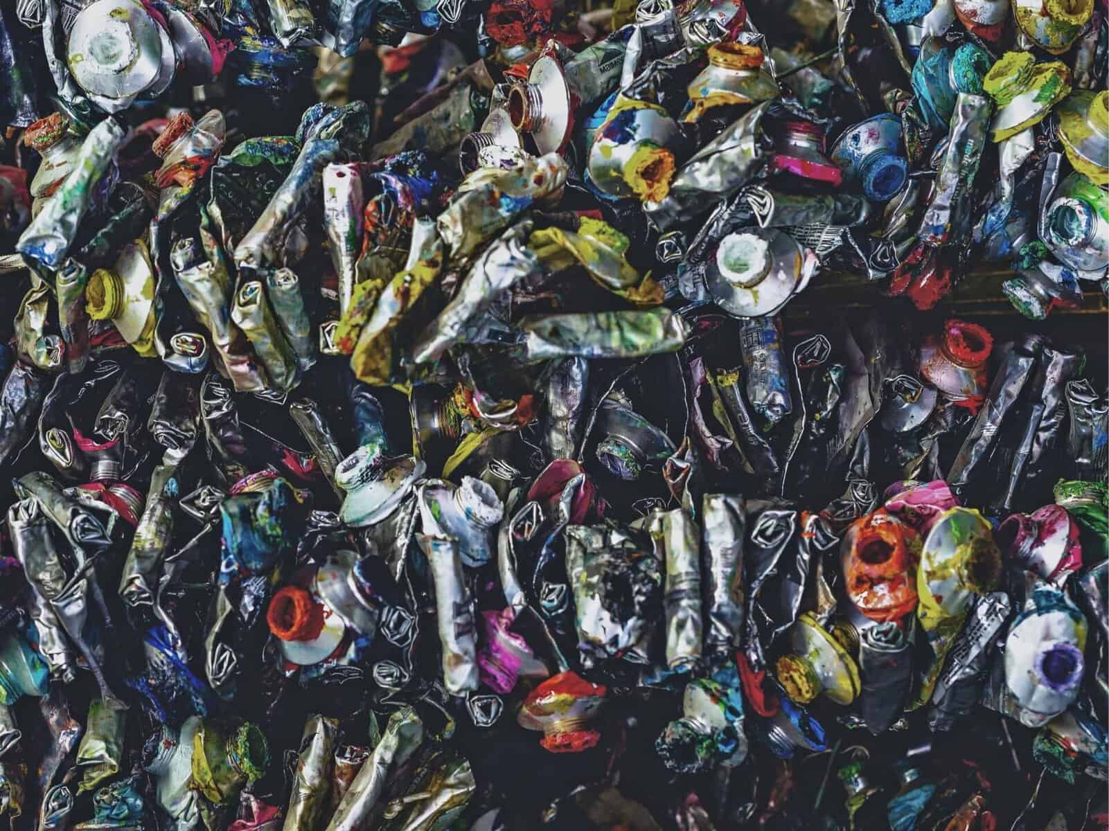 Colorful crumpled aluminum cans, emphasizing waste recycling and eco-conscious disposal solutions.